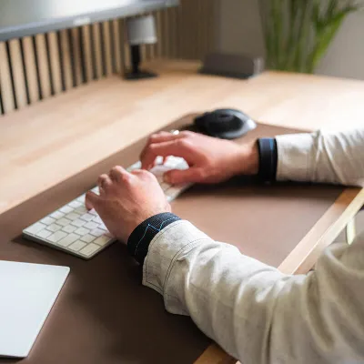 personne assise au bureau avec des poids aux poignets - renforcement musculaire assis sur sa chaise - gym douce quotidienne
